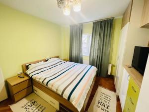 Dormitorio pequeño con cama y TV en 2 Bedroom Apartment and Separate Kitchen 52mp, en Timisoara