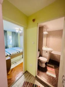 y baño con aseo, cama y bañera. en 2 Bedroom Apartment and Separate Kitchen 52mp, en Timisoara