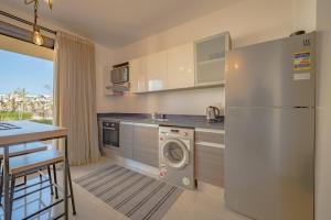  La cuisine est équipée d'un réfrigérateur et d'un lave-vaisselle. dans l'établissement Modern 1-Bedroom Apartment in G-Cribs, El Gouna, pool access, à Hurghada