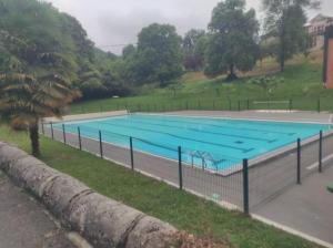 a large swimming pool with a fence around it at Maison au pied de la montagne in Aspet