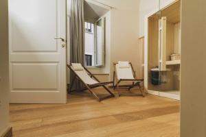 dos sillas sentadas en una habitación al lado de una puerta en Casa Horti Suites en LʼAquila