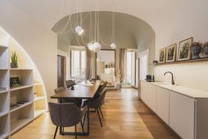 a kitchen and dining room with a table and chairs at Casa Horti Suites in LʼAquila