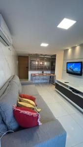 sala de estar con sofá y TV de pantalla plana en Lindo Apartamento p/ 4 pessoas, a 60 m do mar, en João Pessoa