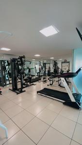 un gimnasio con varias cintas de correr y máquinas en una habitación en Lindo Apartamento p/ 4 pessoas, a 60 m do mar, en João Pessoa