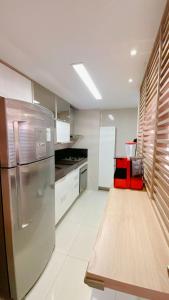 una cocina con nevera de acero inoxidable y armarios blancos en Lindo Apartamento p/ 4 pessoas, a 60 m do mar, en João Pessoa