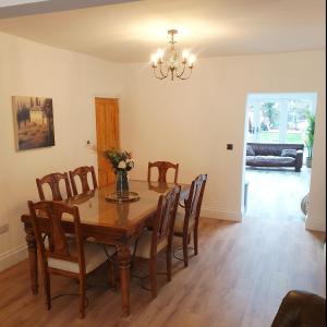 uma sala de jantar com uma mesa de madeira e cadeiras em Dora Cottage em Formby