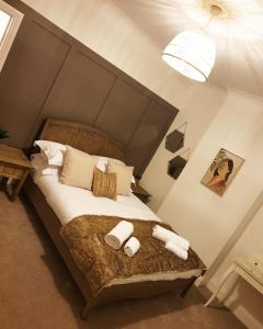 a bedroom with a bed with two rolled towels at Dora Cottage in Formby