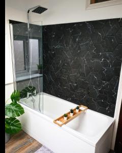 a bathroom with a bath tub with a glass shower at Dora Cottage in Formby