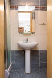 La salle de bains est pourvue d'un lavabo et d'un miroir. dans l'établissement Platy Beach Hotel, à Plati