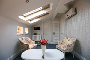 a living room with a table and two chairs at Hotel Les Jardins Carol in Bucharest