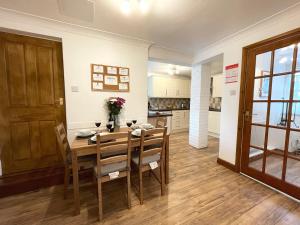 een keuken en eetkamer met een houten tafel en stoelen bij Baree in Keswick