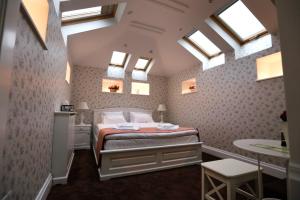 a bedroom with a bed in a room with skylights at Hotel Les Jardins Carol in Bucharest