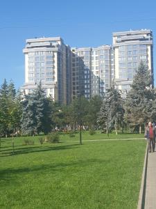 een groep mensen die in een park met hoge gebouwen lopen bij Elegance 1BD apartment with living room in Chişinău