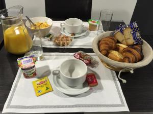a table with a basket of bread and a bowl of pastries at Hôtel Moderne in Maisons-Alfort