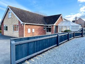 una casa con una valla azul delante de ella en 5-Bedroom Cottage in Healing, Grimsby en Healing