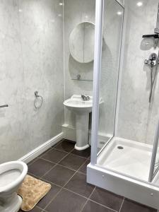 een badkamer met een douche, een toilet en een wastafel bij 5-Bedroom Cottage in Healing, Grimsby in Healing