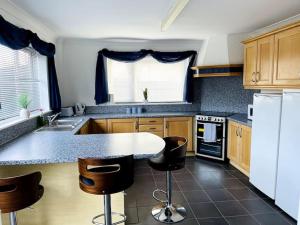a kitchen with a counter and some chairs in it at 5-Bedroom Cottage in Healing, Grimsby in Healing