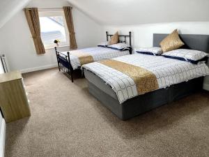 a bedroom with two beds and a window at 5-Bedroom Cottage in Healing, Grimsby in Healing