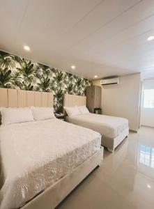 a bedroom with two beds and a wall with a mural at Oasis Hotel in San Andrés