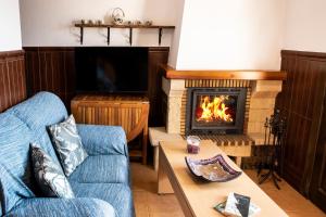 ein Wohnzimmer mit einem blauen Sofa und einem Kamin in der Unterkunft tuGuest Carataunas Apartment Alpujarra IV in Carataunas