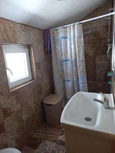 a bathroom with a sink and a toilet and a window at HOUSEHOLD MIKO MERDOVIC - 15e per person in Berane