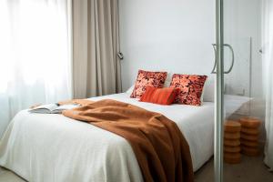 a bedroom with a white bed with orange pillows at Calatrava - Darya Living in Madrid