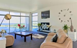 a living room with a large clock on the wall at Spectacular Panoramic 5Bedroom Lakeview in Queenstown