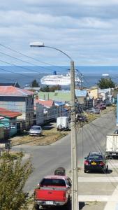 una luz de la calle con coches en una carretera cerca del océano en Hostal Host Patagonia, en Punta Arenas