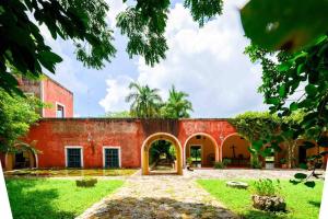 um antigo edifício de tijolos vermelhos com um pátio em Hacienda extraordinaria, jardines preciosos y pirámides 