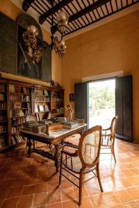 a room with a table and chairs and bookshelves at Hacienda extraordinaria, jardines preciosos y pirámides 