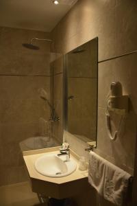 a bathroom with a sink and a shower with a mirror at Hostal Guadiana in Ruidera