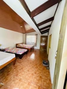 a room with two beds and a wooden floor at Casa Nativa CR in Puerto Jiménez