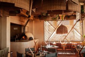 a restaurant with tables and chairs and a fireplace at Hotel Scappata in Progreso