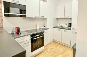 cocina con armarios blancos y fogones en Premium Apartment with Terrace, A/C, FREE WiFi and NETFLIX en Viena