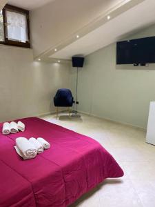sypialnia z różowym łóżkiem i ręcznikami w obiekcie Sweet Dream w mieście Caserta