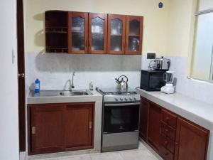 a kitchen with a sink and a stove at Apartamentos en Huanchaco in Huanchaco