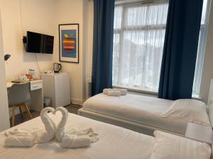 um quarto de hotel com duas toalhas de cisne numa cama em Diana Hotel em Londres