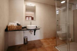 a bathroom with a sink and a glass shower at La Plaza Hostal in Peñíscola
