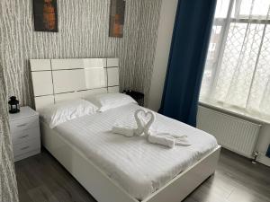 um quarto com uma cama com dois arcos brancos em Diana Hotel em Londres