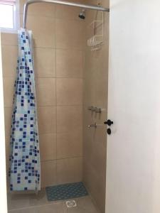 y baño con ducha y azulejos azules y blancos. en Brisas de San Rafael en San Rafael