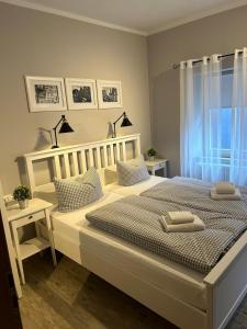 a white bedroom with two beds and a window at Gästehaus Goldenes Lamm in Rothenburg ob der Tauber