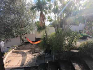 una hamaca de naranja en un jardín con palmeras en Le Clos de Val - Vue mer, en La Possession
