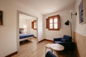 Cette chambre comprend un lit, une chaise et une table. dans l'établissement La Plaza Hostal, à Peñíscola