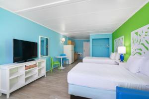a bedroom with two beds and a flat screen tv at Kokomo Suites in Ocean City