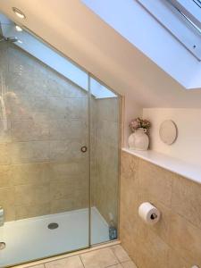 a bathroom with a shower with a glass door at South Downs View in West Meon