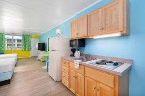 a kitchen with wooden cabinets and a white refrigerator at Kokomo Suites in Ocean City