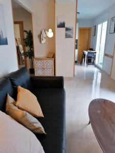 a living room with a black couch and a table at Atico Duque Gran Terraza Parking Free in Cartagena