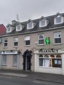 a pharmacy building on the side of a street at Mariners Rest One Bedroom Apartment in Innishannon Village in Cork