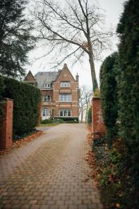 a brick road in front of a large house at Chambres d'hôtes Eucalyptus et Glycine in Genval