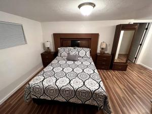 a bedroom with a bed with a black and white comforter at The Heart Of Cruces in Las Cruces